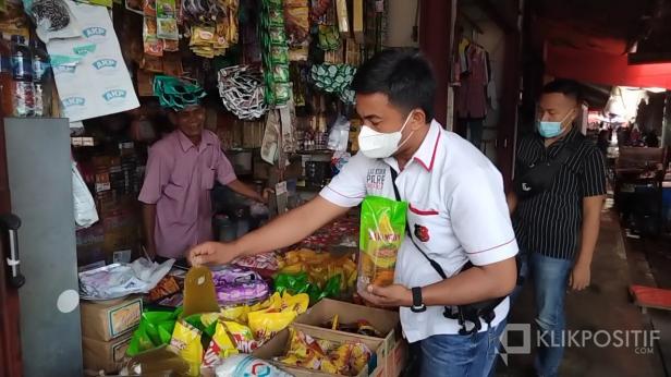 Kanit Tipiter Satreskrim Polres Solok Selatan Bripka Tomi Yudha Timuria saat memantau harga minyak goreng kemasan di Pasar semi modern Padang Aro