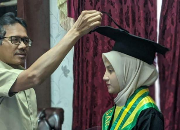 Gubernur Sumbar Irwan Prayitno saat memindahkan jambul toga wisuda anaknya