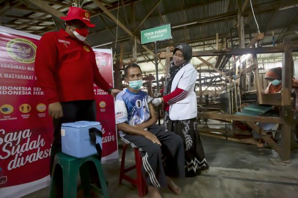 Petugas vaksinasi sedang melakukan pengecekkan data peserta program vaksinasi massal yang dilaksanakan oleh Badan Intelejen Negara Daerah (Binda), Sumatra Barat di Pasar Kubang, Kecamatan Guguak Kabupaten Limapuluh Kota, Sabtu 4 Desember 2021.
