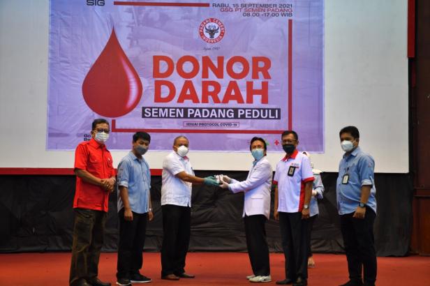 Kepala Departemen Komunikasi  dan Hukum Perusahaan PT Semen Padang Oktoweri (tiga dari kiri) menyerahkan kantong darah yang terkumpul kepada  Kepala Unit Transfusi Darah PMI Padang dr. Widyarman.