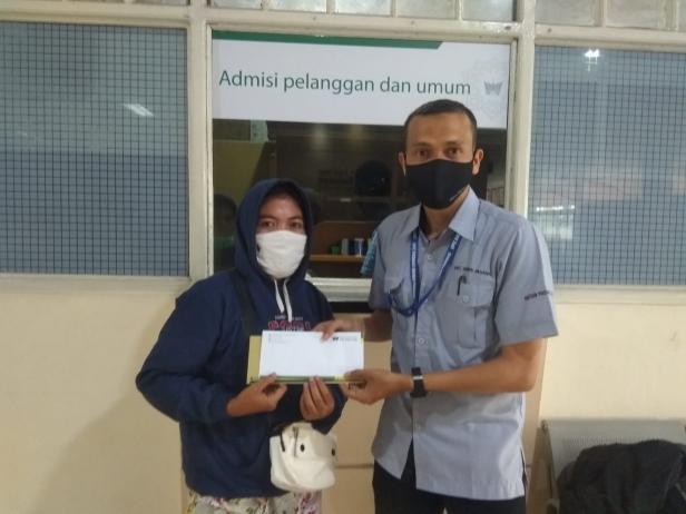Staf UPZ Baznas Semen Padang, Toni (kanan) menyerahkan bantuan biata berobat kepada keluarga penerima manfaat bantuan kesehatan yang dirawat di Rumah Sakit Siti Ramah pada Desember 2021.
