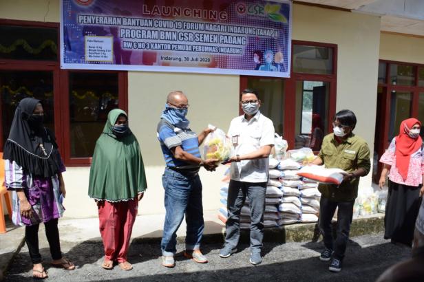 Kepala Unit CSR Semen Padang Muhamad Ikrar (kanan) menyerahkan bantuan sembako secara simbolis kepada warga terdampak Covid-19