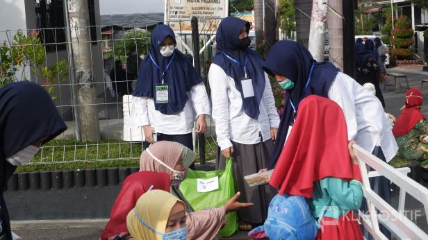 Panitia membagikan lontong kepada jemaah untuk dimakan usai salat Idul Adha