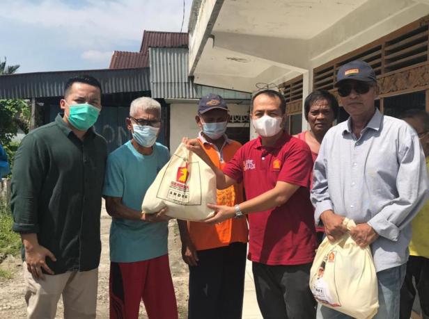 Tokoh masyarakat Jalan Enggang, Parupuk Tabing, Kototangah, Irsal Mawardi membagikan sembako dari anggota DPR RI Andre Rosiade kepada warga.