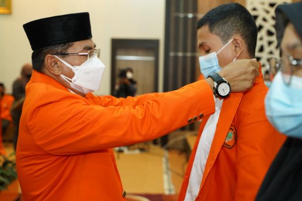 Direktur PNP Surfa Yondri memasankan jacket almamater kepada mahasiswa baru tahun akademik 2021/2022.