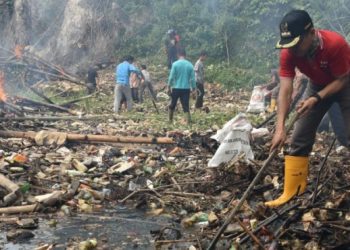 Masyarakat membersihkan tumpukan sampah di aliran Batang Agam