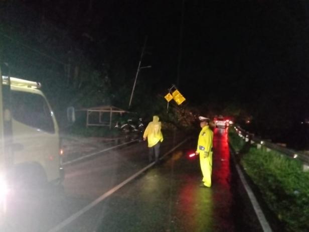 Petugas kepolisian di saat mengatur lalin dikawasan jalan yang tertimbun longsor