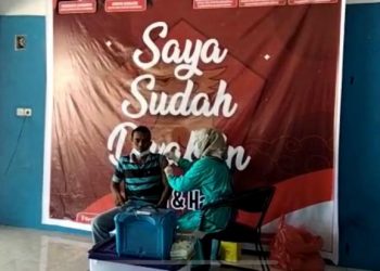 Salah seorang warga Dharmasraya mendapatkan suntikan vaksin dosis pertama di Kantor DPC Gerindra Dharmasraya.