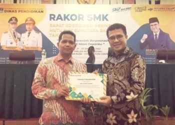 Kepala SMK Semen Padang Gusriadi (kiri) menerima penghargaan dari Kepala Dinas Pendidikan Sumbar Adib Alfikri saat Rakor SMK se-Sumbar yang digelar di Padang pada 27 Januari 2022.