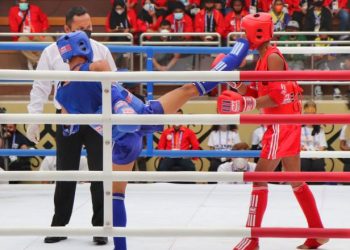 Sepakan Atlet Muay Thai Sumbar, Gilang Dwi Fajri (biru) tepat mengenai wajah atlet Kalimantan Timur Siprianus Gobang (merah) pada PON XX Papua 2021 di GOR STT GIDI, Kab Jayapura