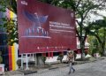 Seorang pria berjalan di depan Baliho peringatan Hari Kesaktian Pancasila yang dipasang di Plaza Kantor Pusat PT Semen Padang, Jumat (1/10/2021). Manajemen PT Semen Padang mengajak seluruh karyawan Semen Padang Group untuk mengibarkan bendera setengah tiang pada tanggal 30 September dan bendera satu
