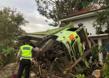 Mobil Dump truk rebah kuda dipinggir jalan usai menabrak dua unit rumah warga