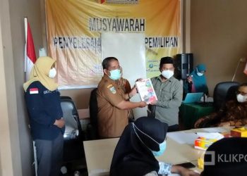 Komisioner Bawaslu Solsel Menyerahkan Buku Pilkada Tahun 2020 Kepada Camat Sangir Jujuan