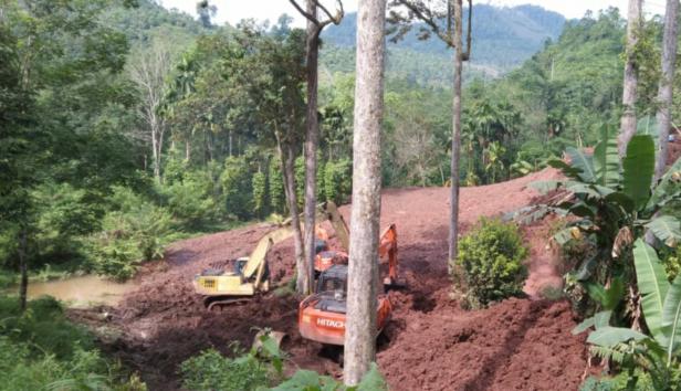 Alat berat sedang mengeruk material longsor proyek instalasi pengolahan air di Tapan