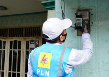 Petugas lapangan PLN tengah memyesuaikan data meteran listrik dengan data yang tercatat di aplikasi PLN Mobile