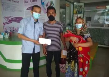 Staf UPZ Baznas Semen Padang Antoni Saputra (kiri) menyerahkan bantuan program kesehatan kepada penerima manfaat yang sedang berutang biaya pengobatan di sebuah RS, beberapa waktu lalu