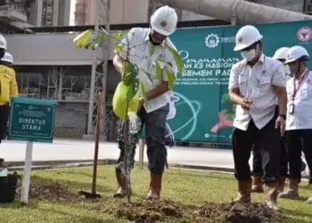 Plt. Direktur Utama  PT Semen Padang Asri Mukhtar,  menyiram pohon yang baru ditanam pada acara penghijauan di area Pabrik Indarung VI,  Senin (14/2/2022).  Pada 2022 ini, PT Semen Padang merencanakan menanam sebanyak 1000 batang pohon  di sekitar pabrik.