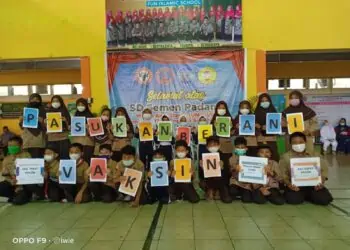 Siswa SD Semen Padang foto bersama usai mengikuti vaksinasi anak usia 6-11 tahun dengan memegang kertas karton bertuliskan "Pasukan Berani Vaksin"