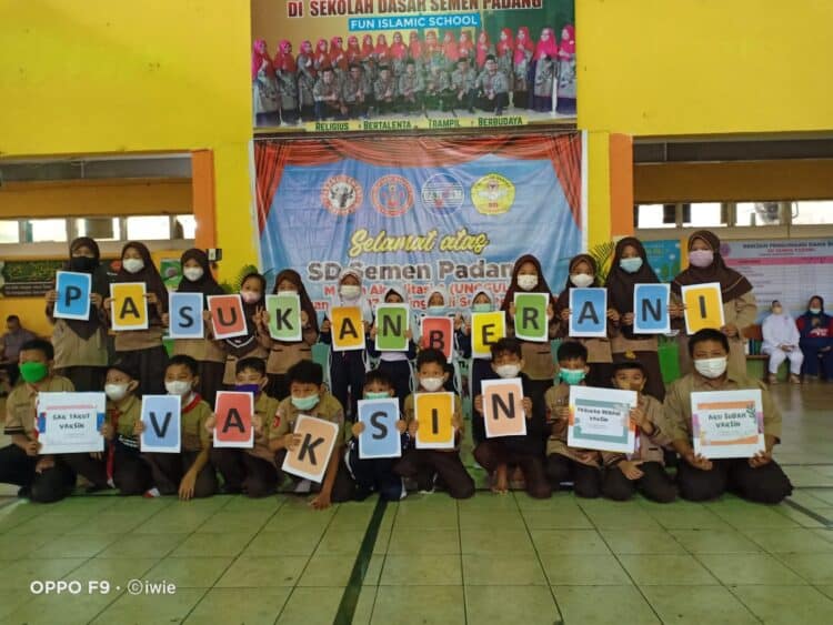 Siswa SD Semen Padang foto bersama usai mengikuti vaksinasi anak usia 6-11 tahun dengan memegang kertas karton bertuliskan "Pasukan Berani Vaksin"