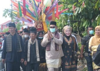 Bupati Solok, H. Epyardi Asda bersama ketua TP-PKK, Ny. Emiko saat bersama masyarakat dalam pawai budaya di Singkarak.(Ist)