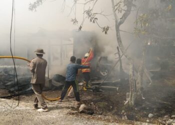 Petugas Damkar Solsel dibantu masyarakat berusaha memadamkan api di Sungai Aro Kecamatan KPGD.