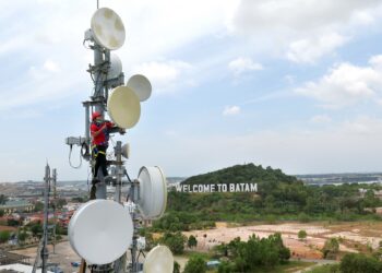 Teknisi Telkomsel Batam, Johardi, memperbaiki perangkat jaringan broadband di wilayah Batam Center, Batam, Selasa (9/3).