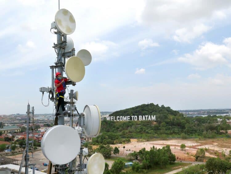 Teknisi Telkomsel Batam, Johardi, memperbaiki perangkat jaringan broadband di wilayah Batam Center, Batam, Selasa (9/3).