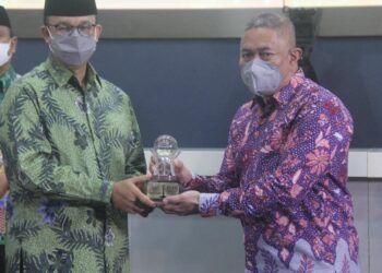 Penyerahan penghargaan secara simbolis oleh Gubernur DKI Jakarta Anies Baswedan kepada M. Feriadi Soeprapto, Presiden Direktur JNE.