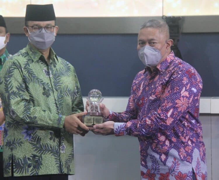 Penyerahan penghargaan secara simbolis oleh Gubernur DKI Jakarta Anies Baswedan kepada M. Feriadi Soeprapto, Presiden Direktur JNE.
