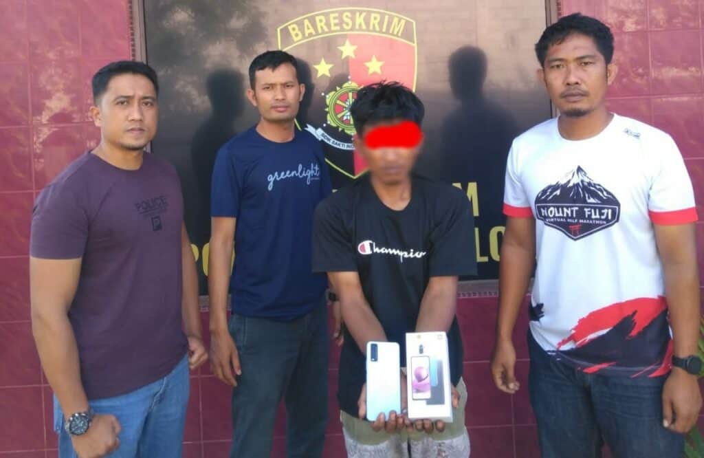 Pelaku pencurian menunjukkan handphone hasil curiannya usai tertangkap tim Unit Reskrim Polsek Solok Kota.(Ist)