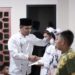 Bahagia, Wakil Wali Kota Solok tampak senang saat menyerahkan santunan bagi anak yatim di lingkungan Masjid Nurul Huda Tembok.(Prokomp)