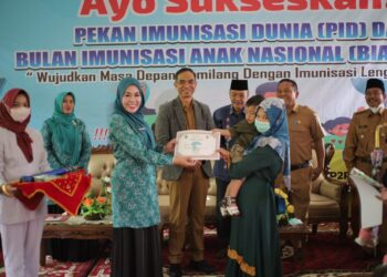 Disaksikan Sekda Medison,Ketua TP-PKK Kabupaten Solok, Ny. Emiko menyerahkan sertifikat terhadap anak peserta imunisasi.(Ist)