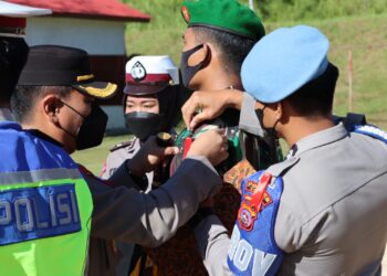 Kapolres Solok,AKBP Apri Wibowo menyematkan pita tanda operasi kepada personel gabungan saat apel di Mapolres Solok.(Ist)