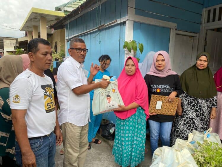 Pengurus Partai Gerindra menyerahkan bantuan paket sembako kepada masyarakat kurang mampu.