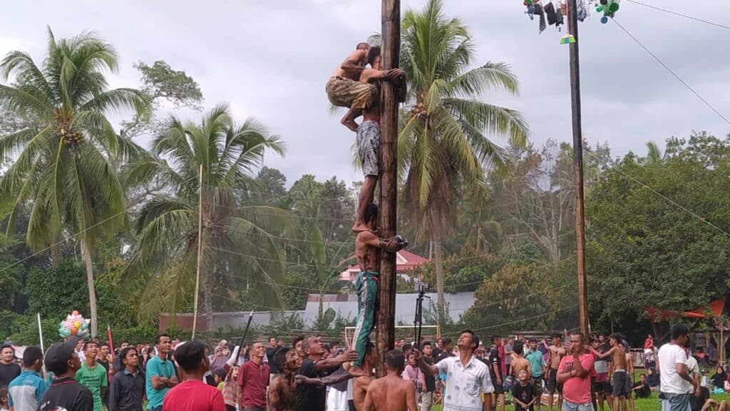 Masyarakat Nagari Muaro Paneh Solok menikmati hiburan panjat Pinang di Jorong Balai Pinang.(Klikpositif)