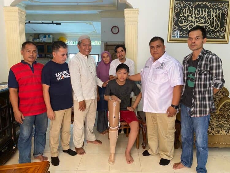 Ketua DPC Partai Gerindra Kota Padang Verry Mulyadi bersama pengurus DPD Partai Gerindra Sumbar foto bersama dengan Raditya Alvaro usai menyerahkan kaki palsu di kediaman Raditya Alvaro di  Sungai Lareh, Kecamatan Koto Tangah, Kota Padang, dua hari jelang Lebaran Idul Fitri 1443 H.