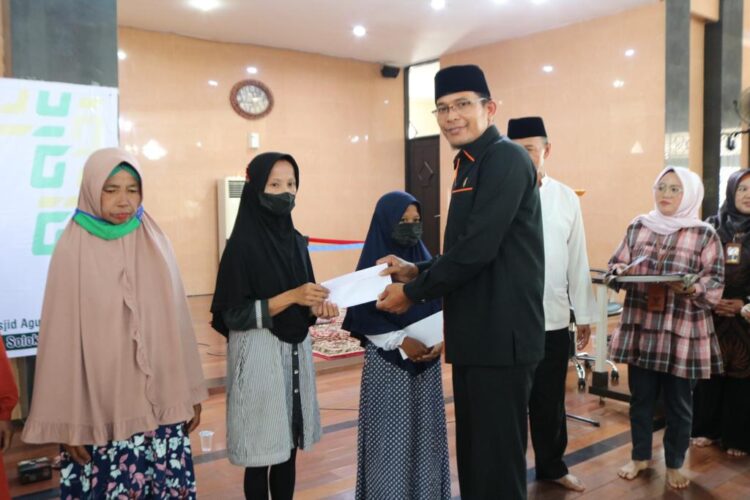 Wakil Ketua Komisi I DPRD Kota Solok, Taufiq Nizam menyerahkan bantuan dana pendidikan dari Baznas kepada penerima di Masjid Agung Al-Muhsinin,(Prokomp)