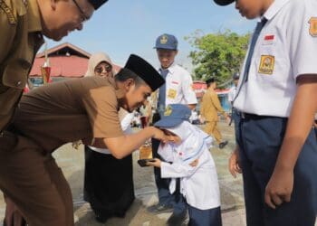 Wawako Solok, Ramadhani Kirana Putra menyerahkan trophy kepada salah seorang siswi berprestasi di SMP N 2 Kota Solok.(Prokomp)