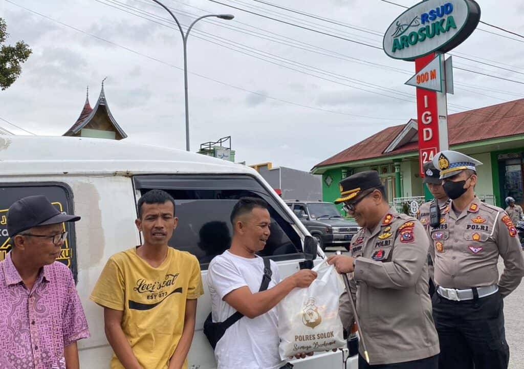 Kapolres Solok, AKBP Apri Wibowo menyerahkan bantuan sembako kepada sopir angkot di depan RSUD Arosuka.(Ist)