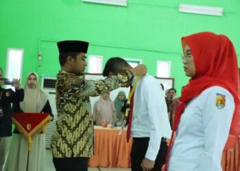 Wakil Wali Kota Solok, Dr. Ramadhani Kirana Putra mengalungkan tanda peserta pembelajaran klasikal di SKB Kota Solok.(Prokomp)