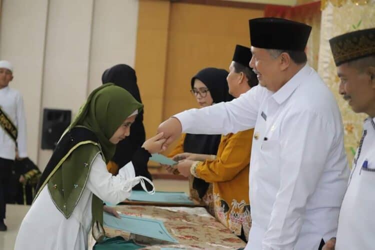 Salah seorang peserta wisuda tahfiz Kota Solok bersalaman dengan Wali Kota Solok, H. Zul Elfian Umar.(Prokomp)