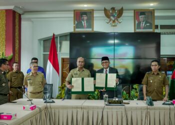 Asisten I Kabupaten Solok, Syahrial dan Wako Padang, Hendri Septa menunjukkan nota kesepakatan kerjasama kedua daerah.(Ist)