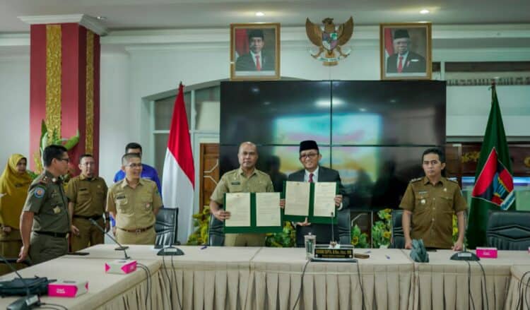 Asisten I Kabupaten Solok, Syahrial dan Wako Padang, Hendri Septa menunjukkan nota kesepakatan kerjasama kedua daerah.(Ist)