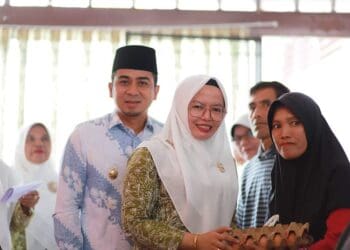 Ketua GOW Kota Solok, Ny. Dona Ramadhani bersama Wawako Solok menyerahkan bantuan lebaran untuk warga kurang mampu.(Prokomp)