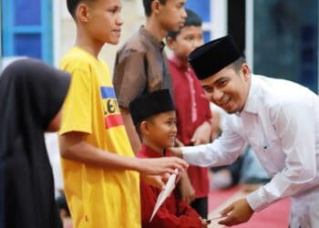 Raut bahagia, Wawako Solok Ramadhani Kirana Putra tampak senang saat menyerahkan santunan pada anak yatim.(Prokomp)