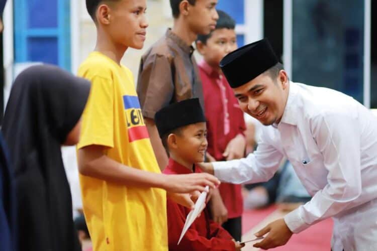 Raut bahagia, Wawako Solok Ramadhani Kirana Putra tampak senang saat menyerahkan santunan pada anak yatim.(Prokomp)