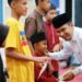 Raut bahagia, Wawako Solok Ramadhani Kirana Putra tampak senang saat menyerahkan santunan pada anak yatim.(Prokomp)