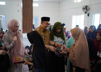 Bupati Solok, H. Epyardi Asda dan keluarga membagikan zakat pada masyarakat kurang mampu di Nagari Singkarak.(Ist)