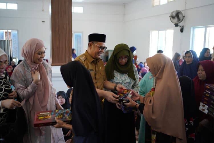 Bupati Solok, H. Epyardi Asda dan keluarga membagikan zakat pada masyarakat kurang mampu di Nagari Singkarak.(Ist)