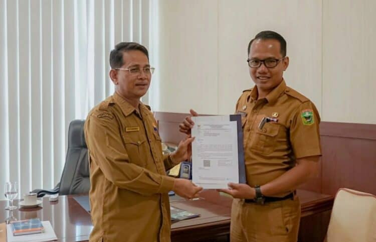 Kadisdukcapil Kabupaten Solok, Riki Karnova menyerahkan hasil evaluasi penilaian penyelenggaraan pelayanan publik dari Menpan RB.(Ist)